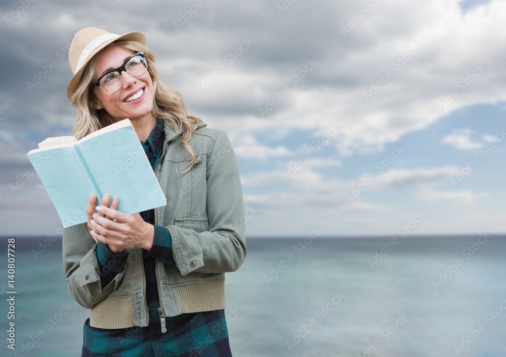 Composite image of Woman with book in front of sea