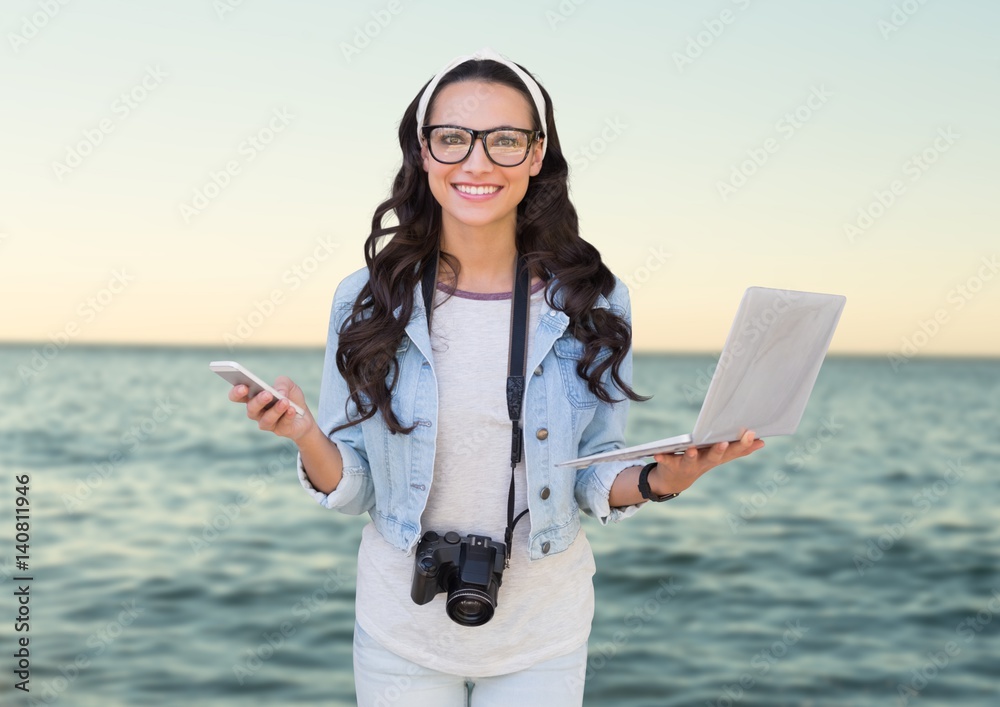 Composite image of Woman with phone and laptop in front of sea