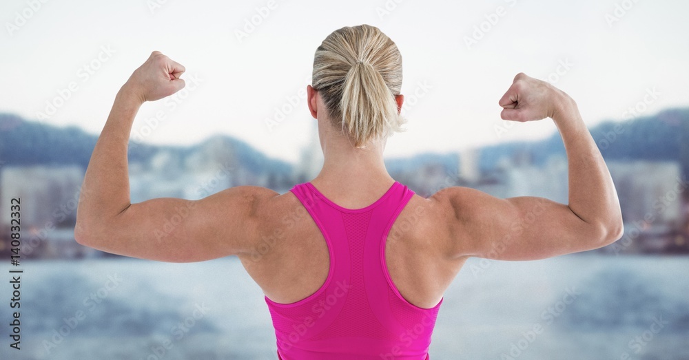 Fit woman flexing muscles against digitally generated background