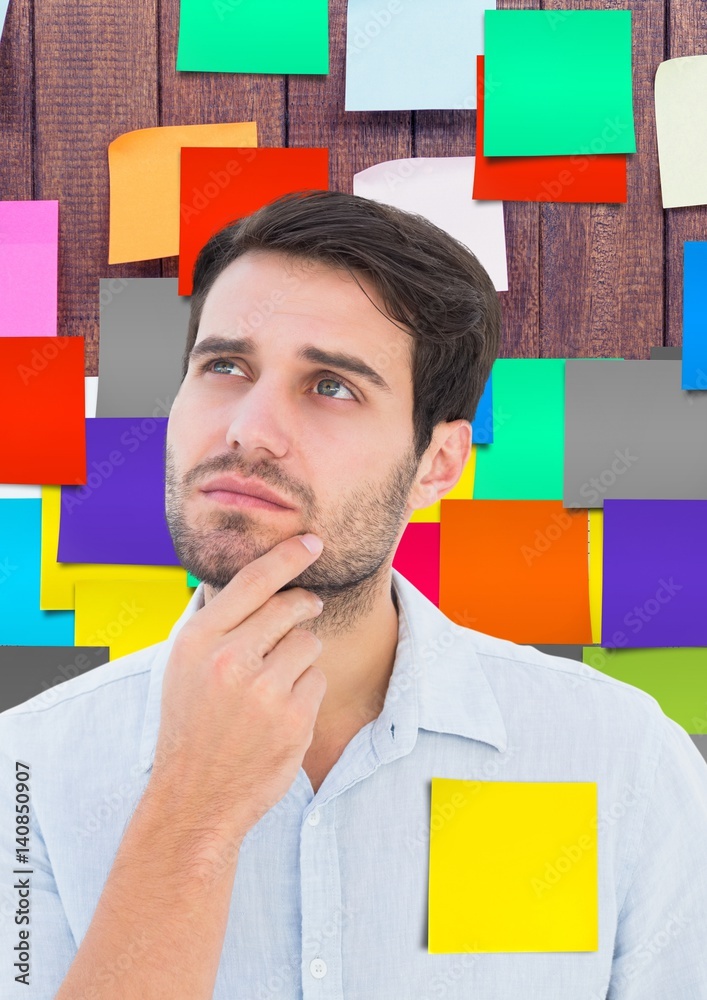 Thoughtful male executive standing against sticky notes