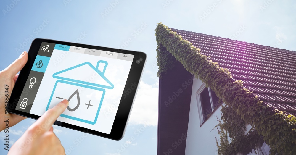 Hand holding digital tablet with home security icons on screen