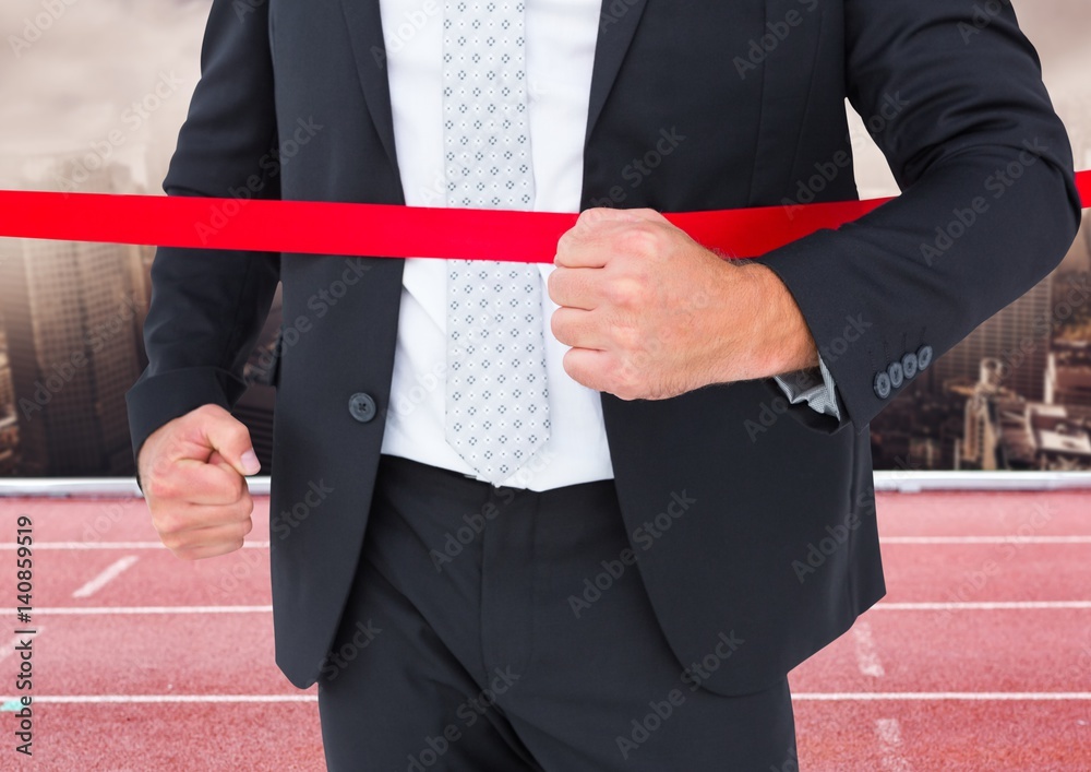 Businessman crossing the finish line in ground