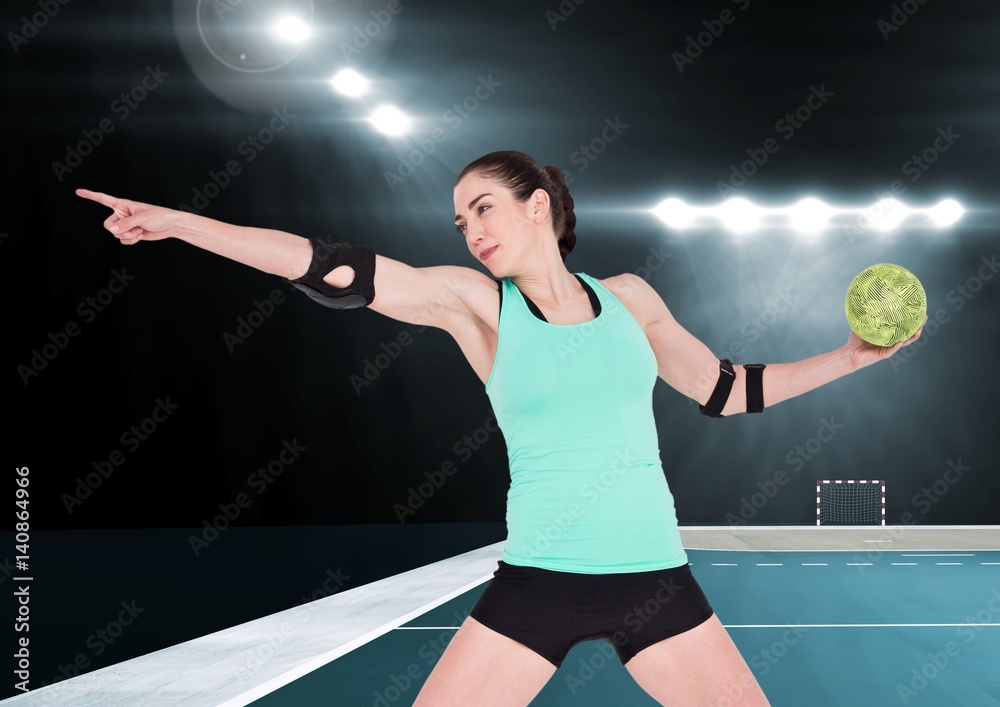 Athlete playing handball against stadium in background