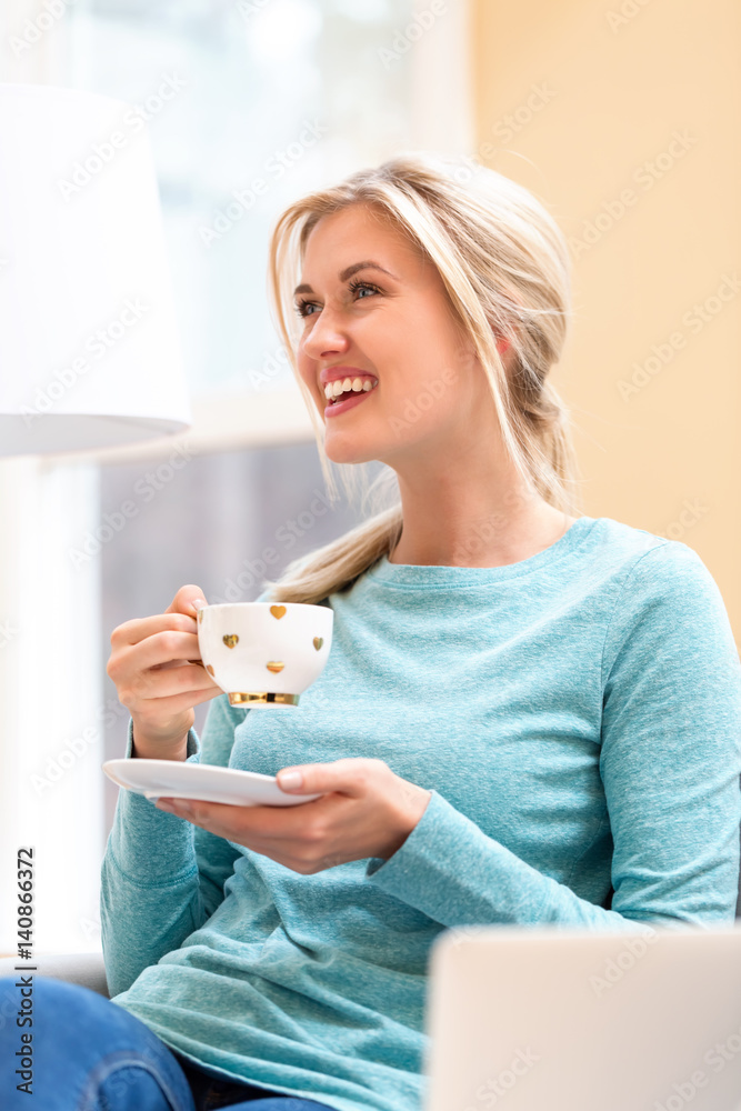 Happy young woman drinking coffee