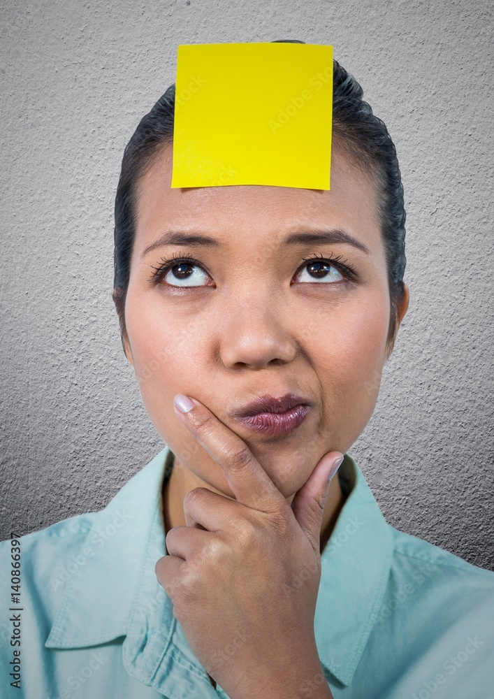 困惑的女人额头上有一张空白的便签