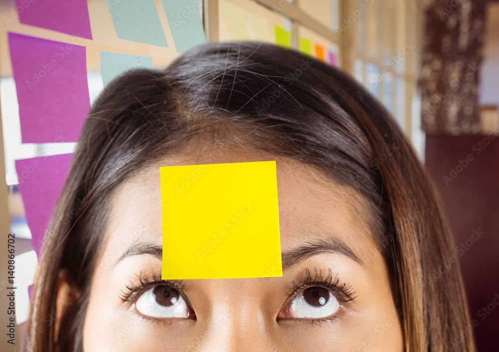 Close-up of woman with sticky note on her forehead