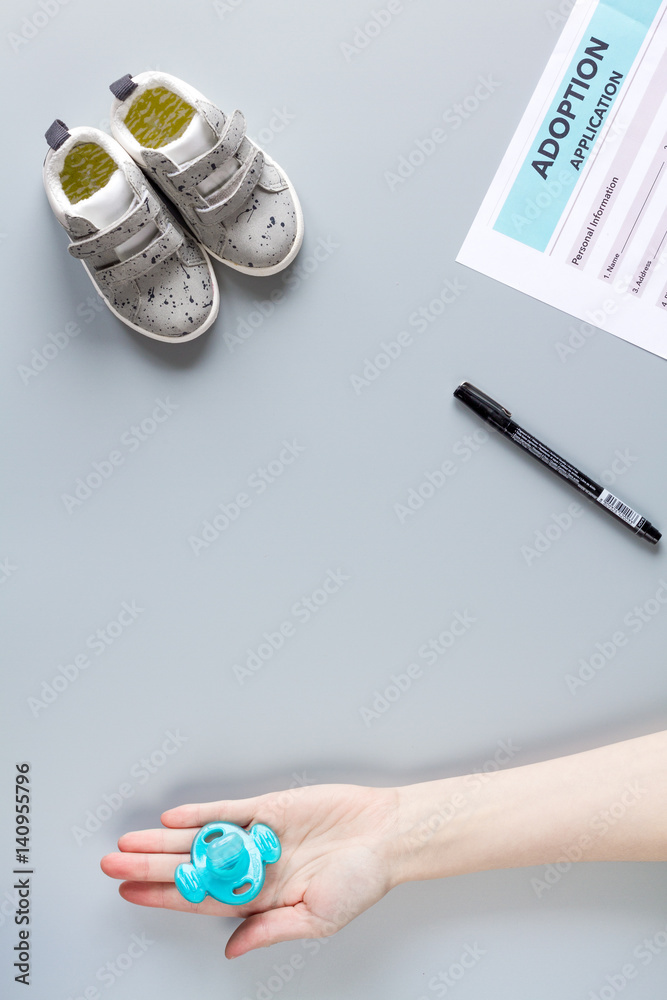 adoption form and children shoes on desk background top view mock up