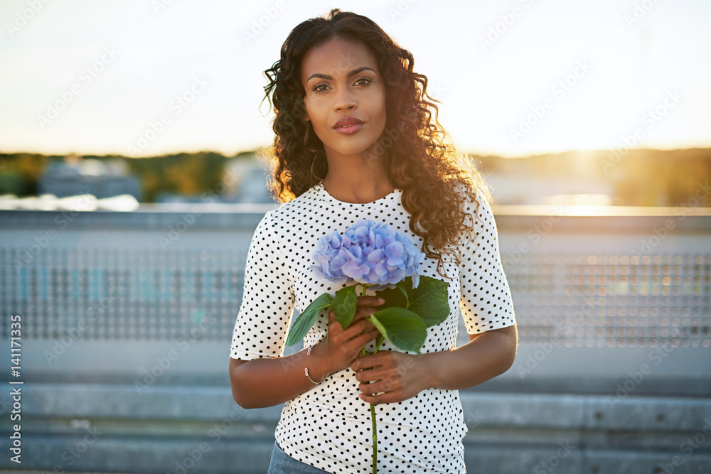 Pretty afro american woman holding a flower