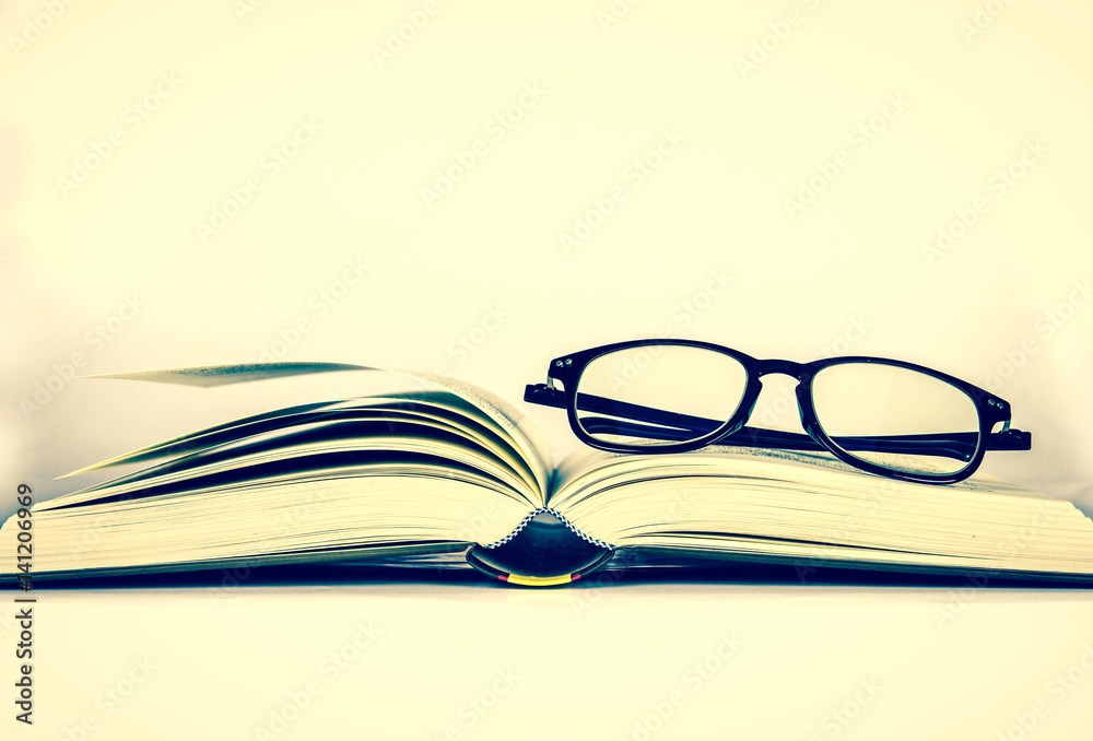 black rimmed glasses placed on opened book