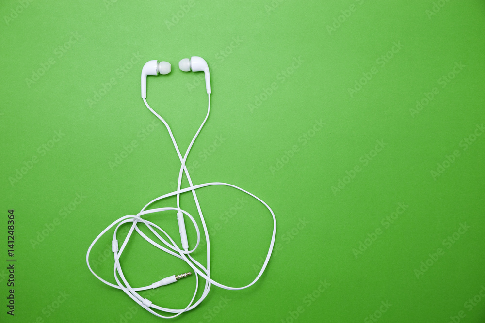 earphone on green paper background.