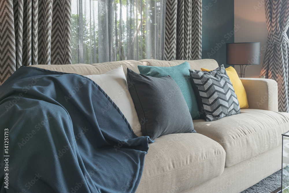 colorful pillows on modern sofa in blue modern living room