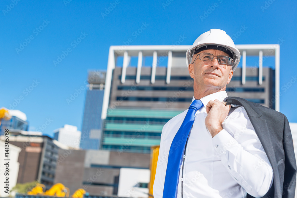 阳光明媚的夏日，穿着西装的高级优雅建筑工人在施工现场