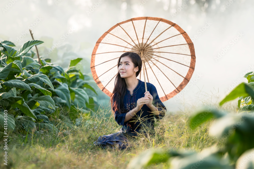 Woman farmer harvesting tobacco at countryside.