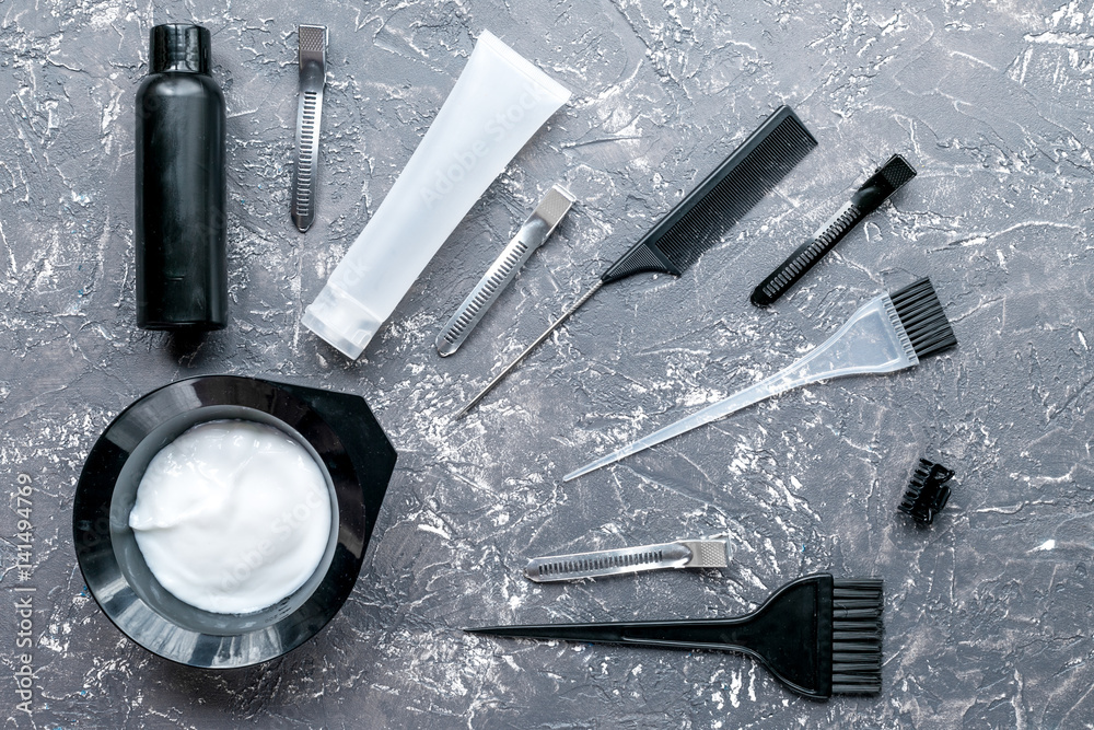 hair dye with brush on gray table background top view