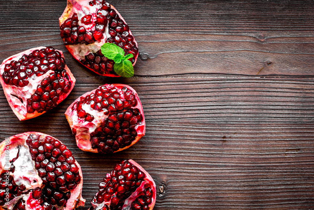 sliced pomegranate on wooden background top view