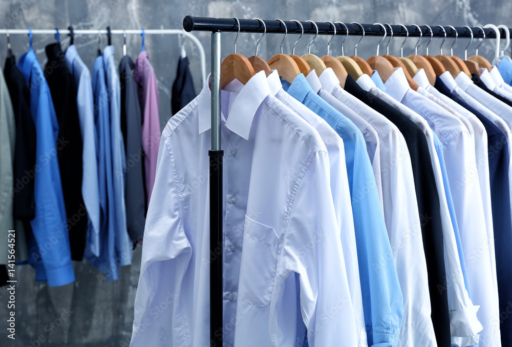 Rack of clean clothes hanging on hangers at dry-cleaning