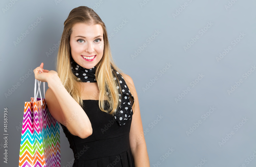 Happy young woman holding many shopping bags