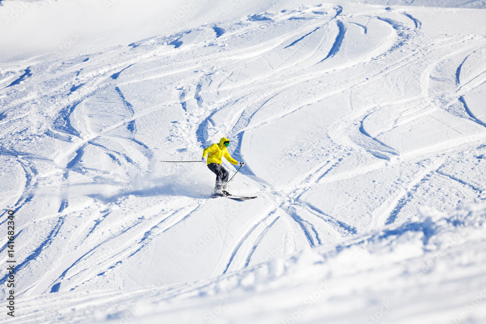 Sporty man skiing downhill in high mountains