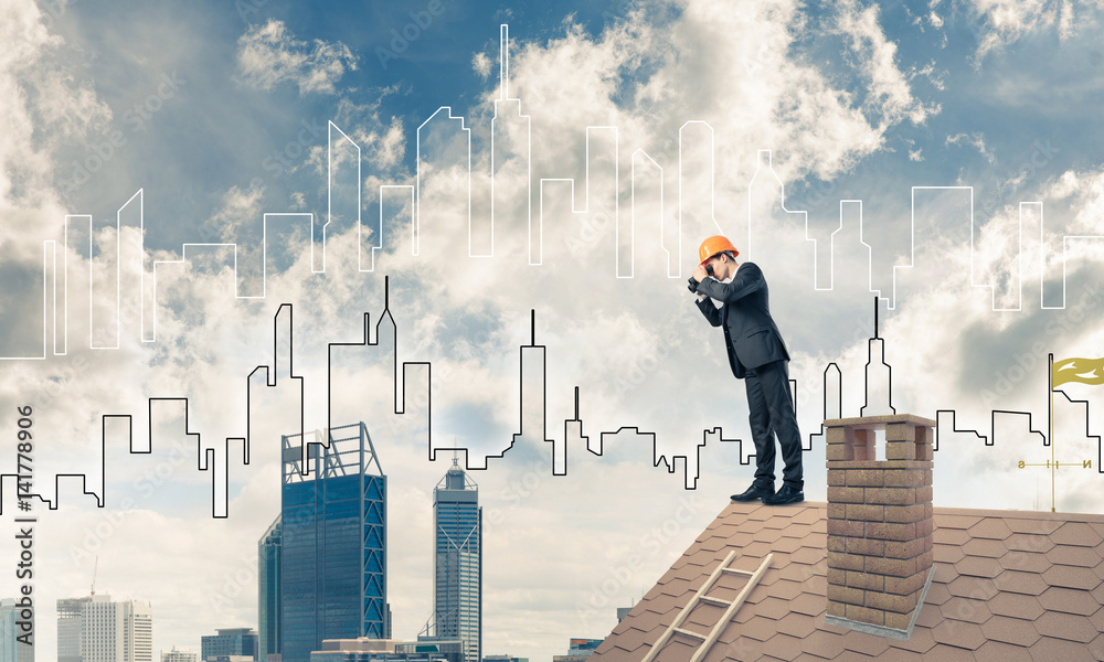 Engineer man standing on roof and looking in binoculars. Mixed m