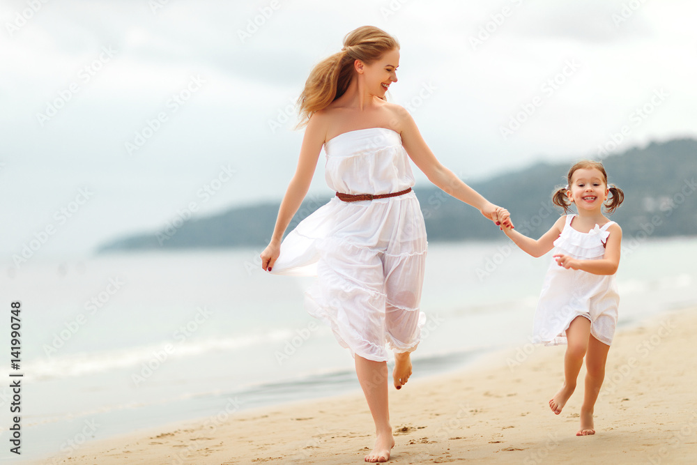 happy family  mother and daughter run, laugh and play at beach