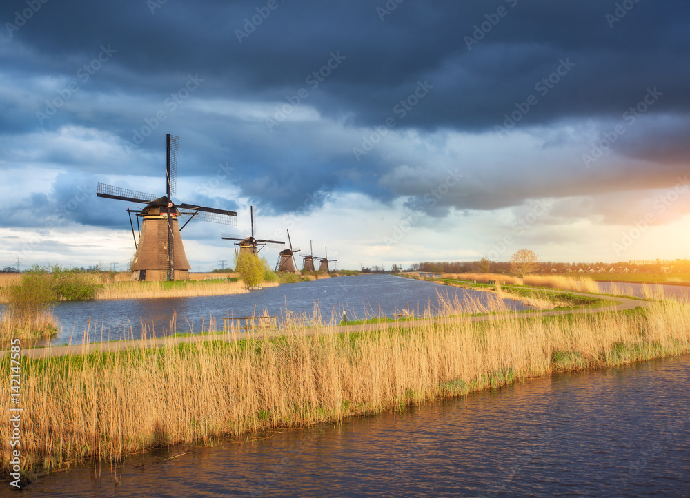 Amazing windmills. Rustic landscape with traditional dutch windmills near the water canals and blue 