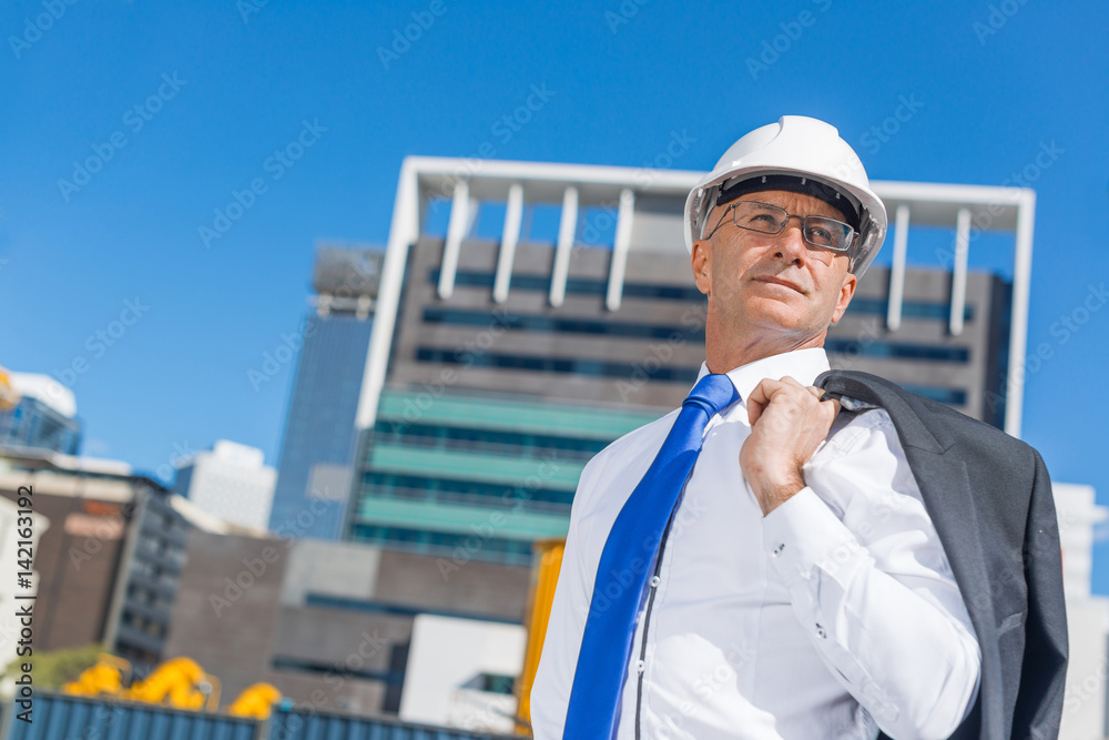 阳光明媚的夏日，穿着西装的高级优雅建筑工人在施工现场