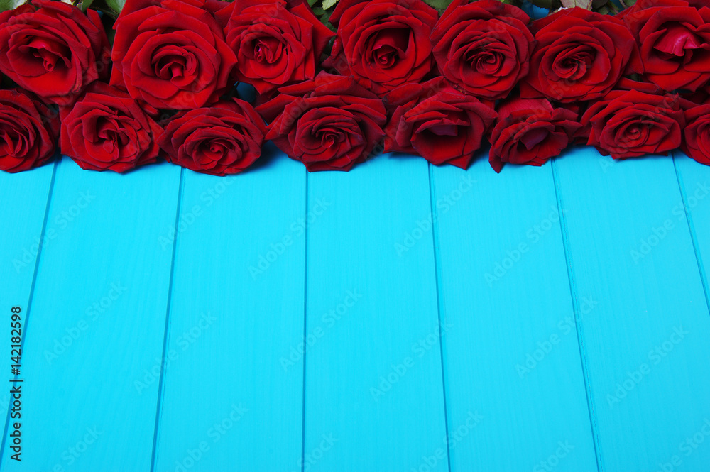 Red roses flowers on blue wood.