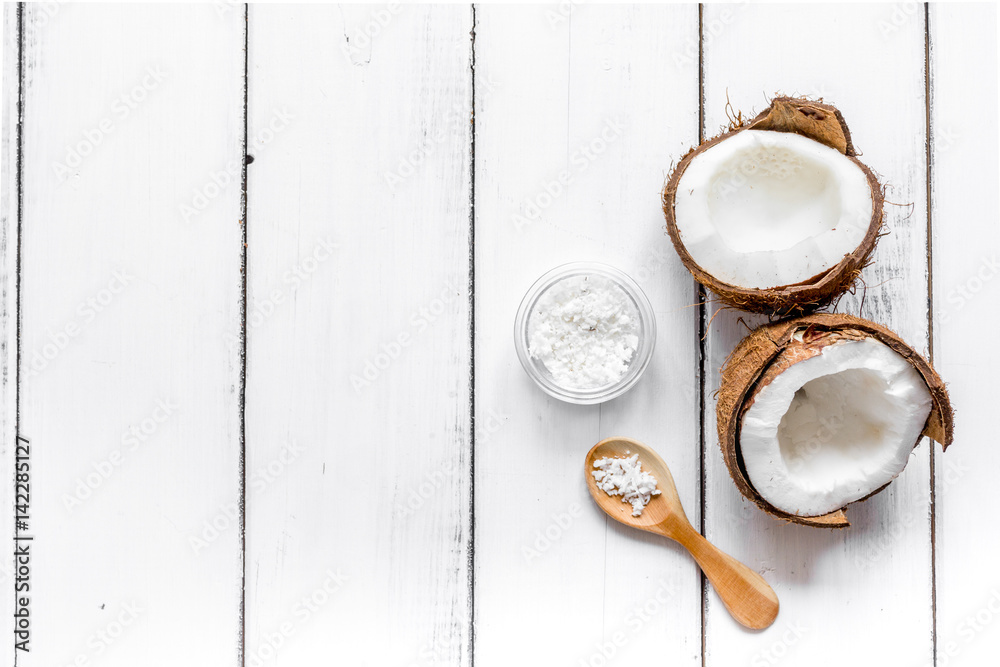 fresh coconut with cosmetic oil in jar on white background top view