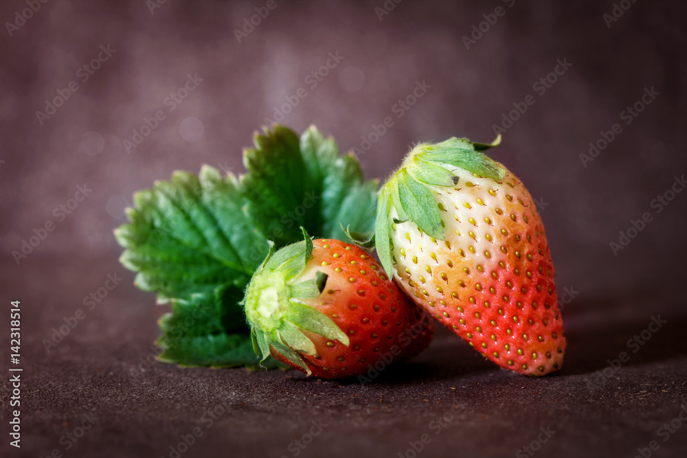 Close up Red Strawberries and leaf with black stone background