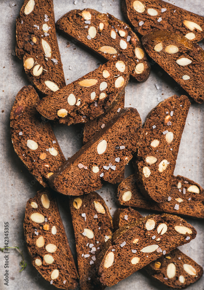 Close-up of dark chocolate and sea salt Biscotti with almonds on baking paper, top view, vertical co