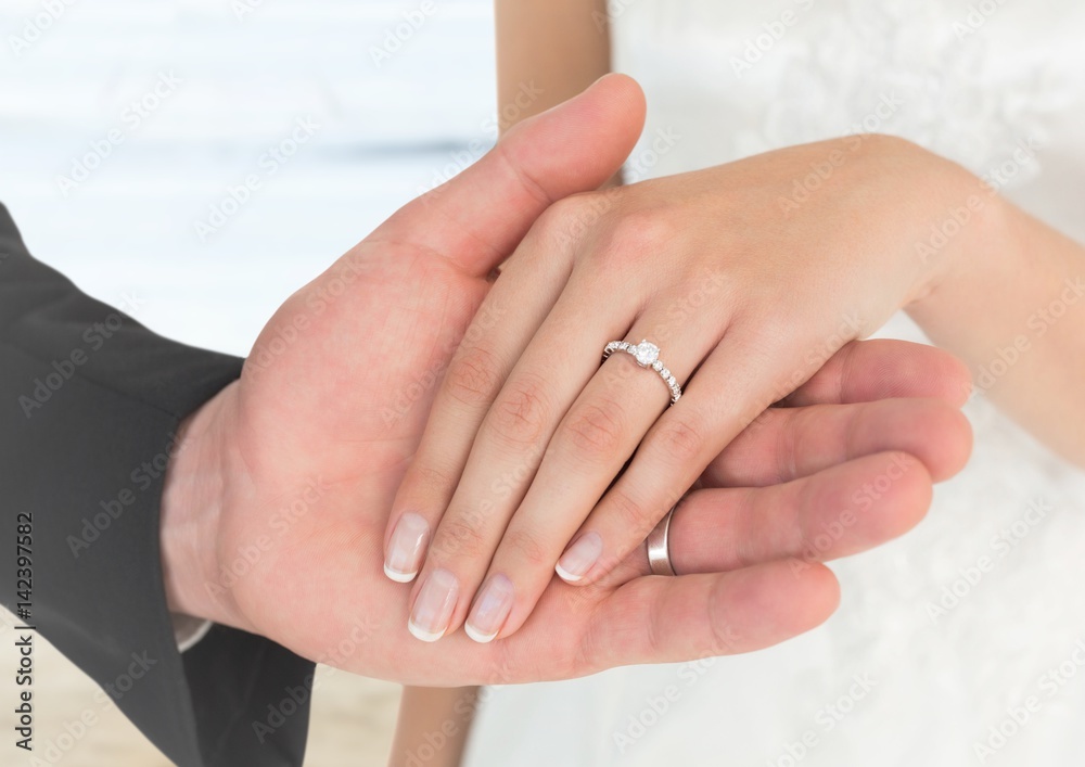 Bride and groom hands at blurry beach