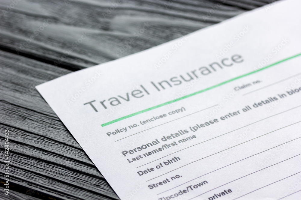 Travel preparation concept with insurance on wooden table