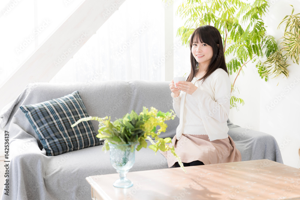 attractive asian woman relaxing in living room