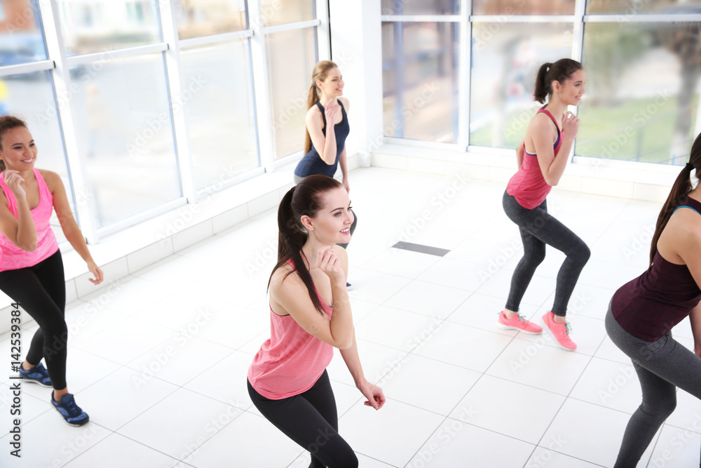 Young sporty women training in dance hall