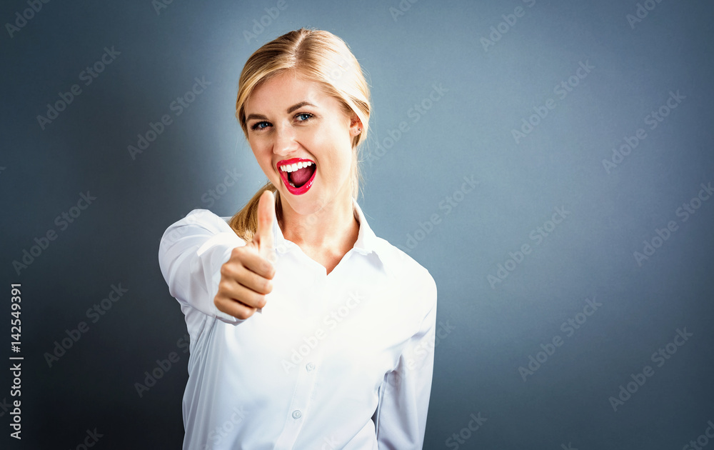 Happy young woman giving a thumbs up