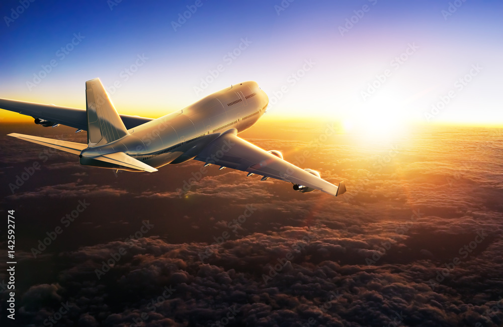 Airplane flying above clouds during sunset