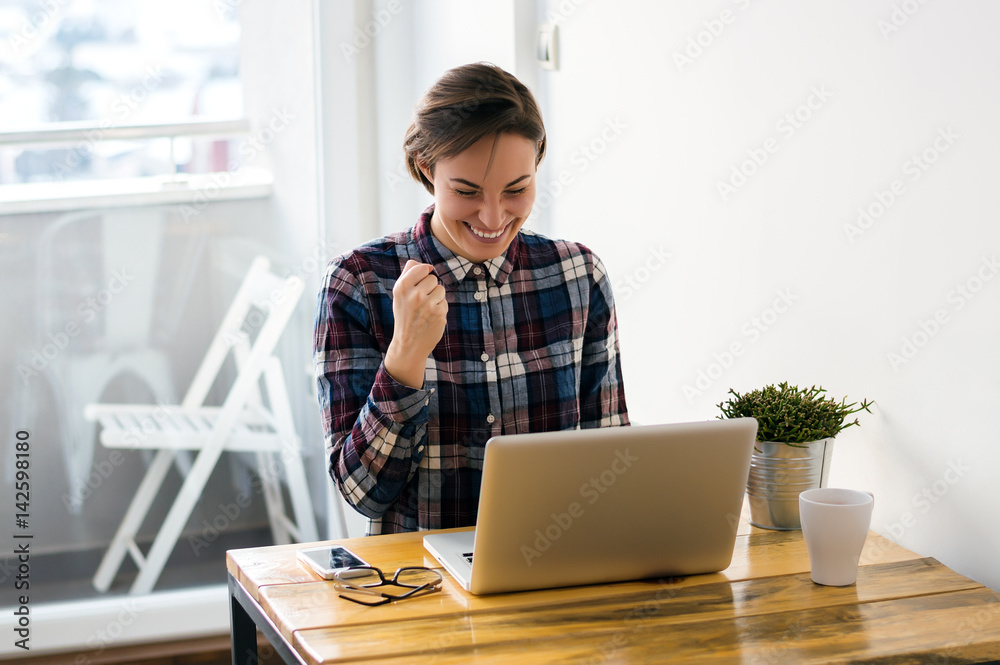 Happy girl in the great mood, reading some good news on the web