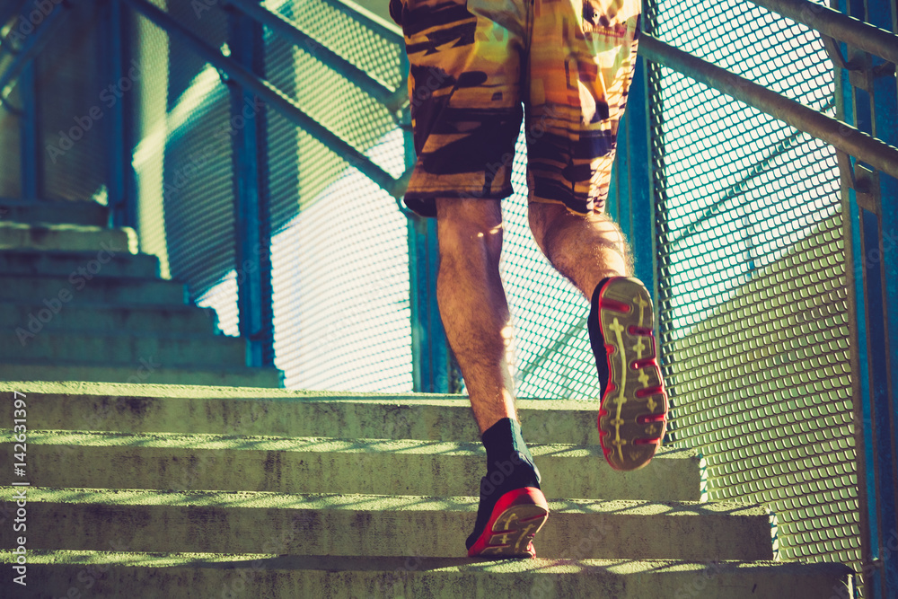 young man running up the stairs outdoor in the city