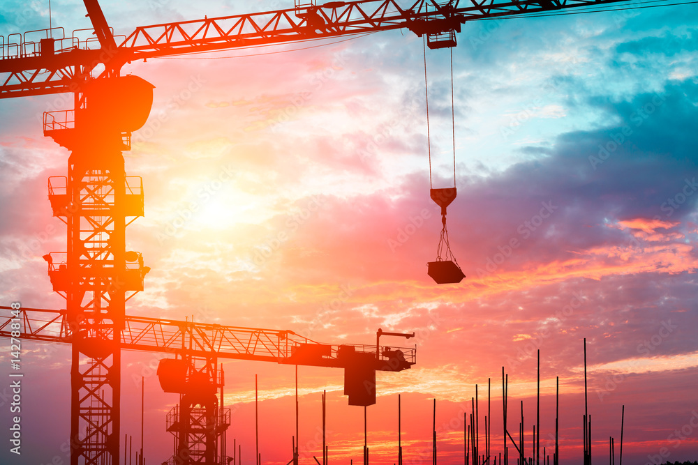 Crane and building construction site at sunset