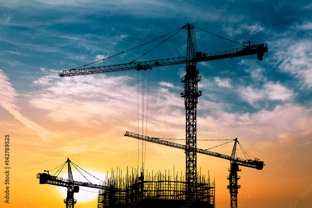 Crane and building construction site at sunset