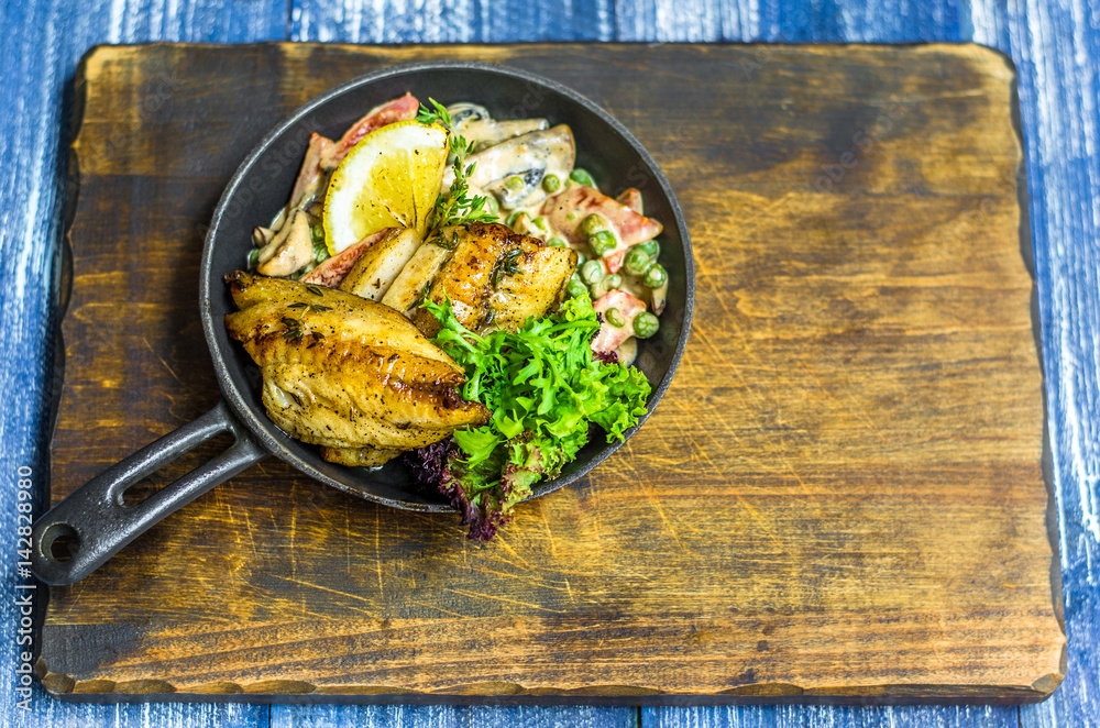 Frying pan with fish, lemon and herbs