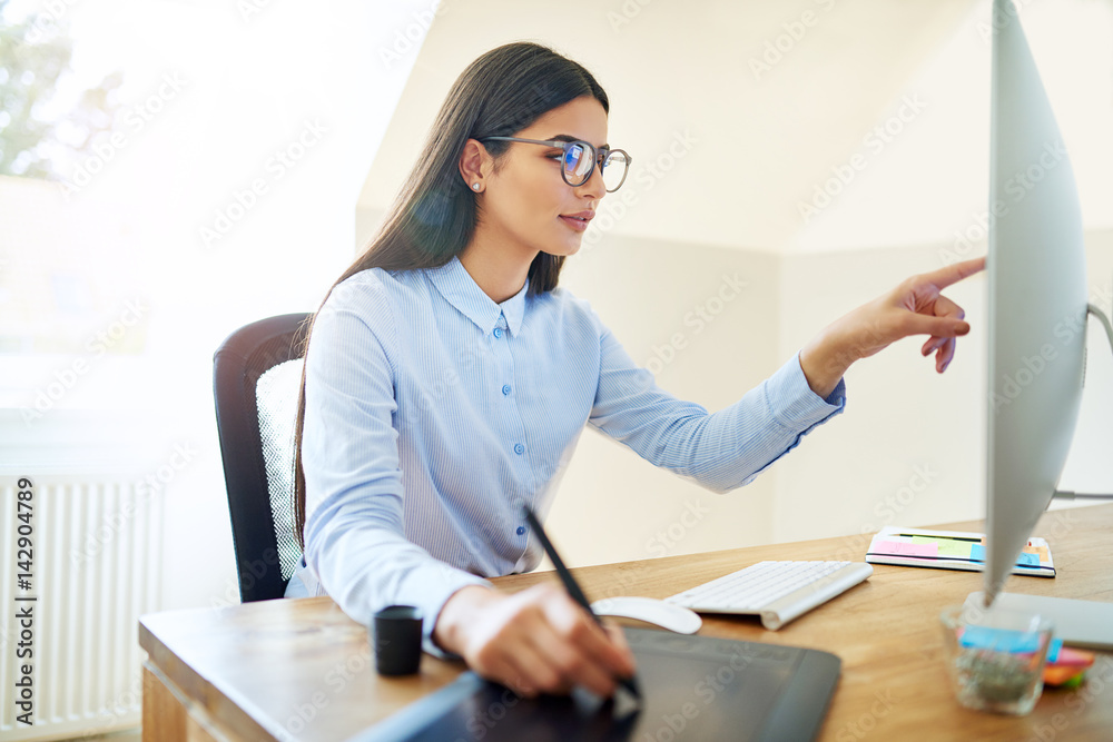 Artist pointing at monitor while working at desk