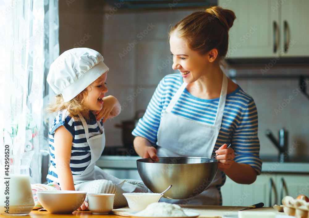 happy family in kitchen. mother and child preparing dough, bake cookies