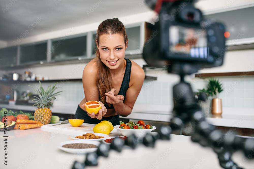 Young female blogger recording content for videoblog in Kitchen.