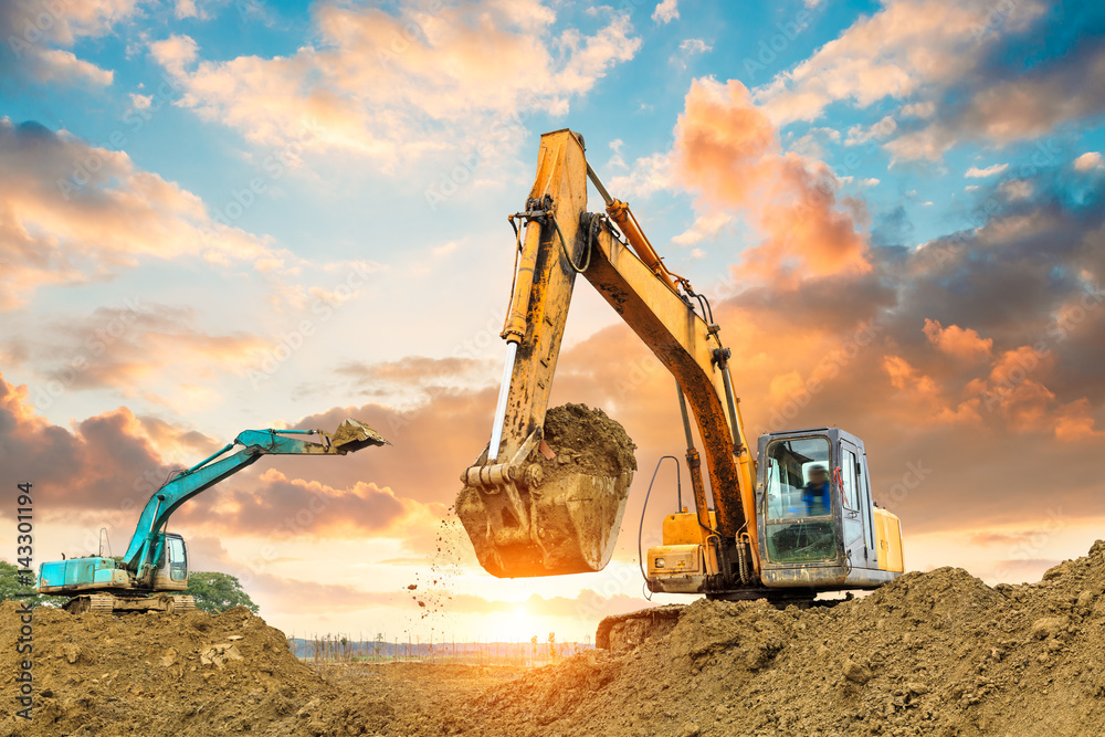 excavator in construction site on sunset sky background