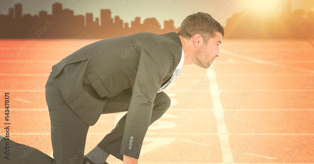 Business man at start line against orange flare with skyline