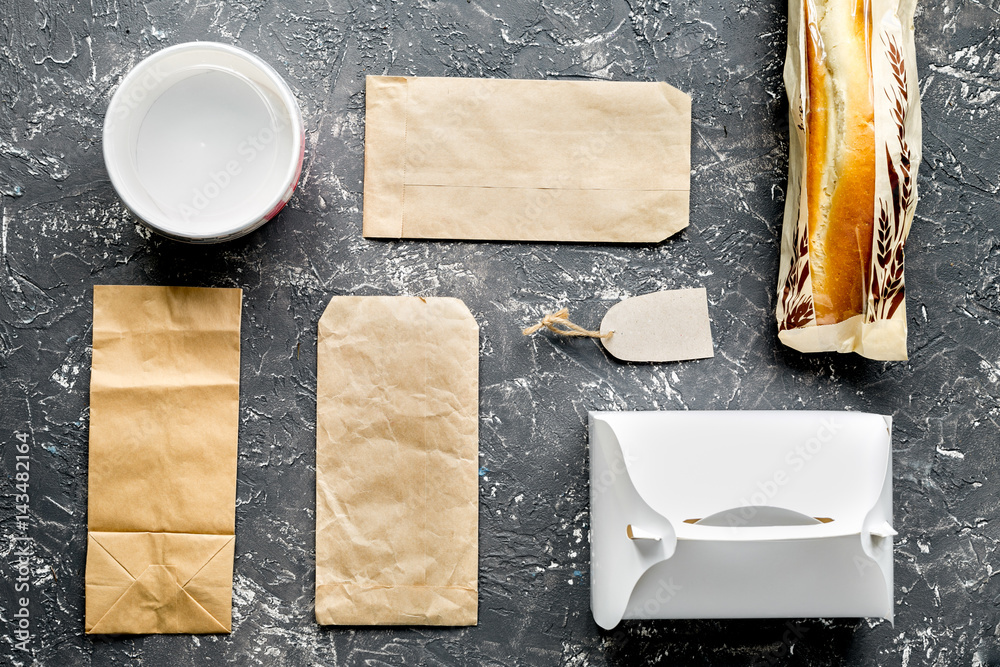 food delivery with paper bags and sandwich on gray background top view