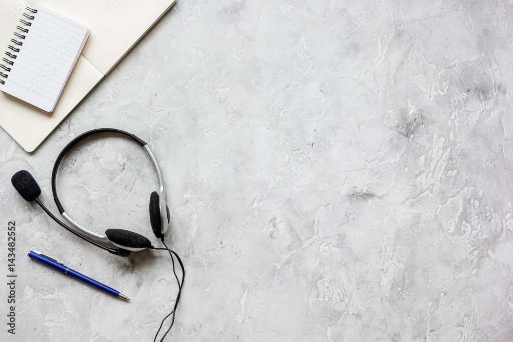 Office desk with headset and keyboard stone background top view mockup