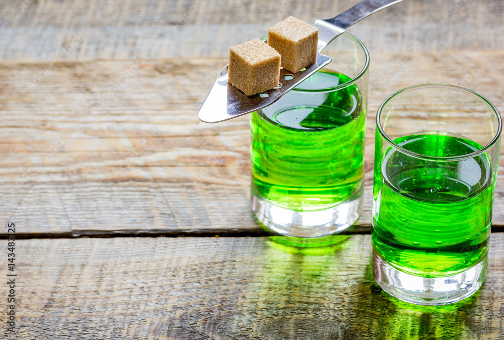 absinthe in glass with sugar cubes on wooden background mock up