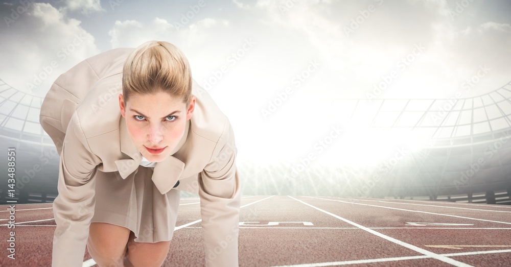 Business woman at start line on track against flares